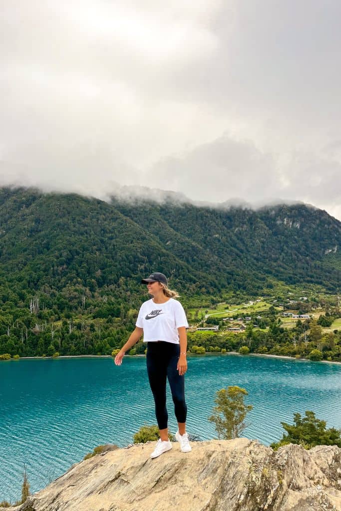 Person standing at the lookout at Bob's Cove in Queenstown with the blue lake in the background