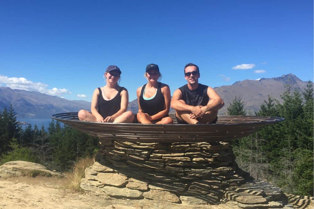 3 people siting in the Basket of Dreams at the Queenstown Hill Lookout