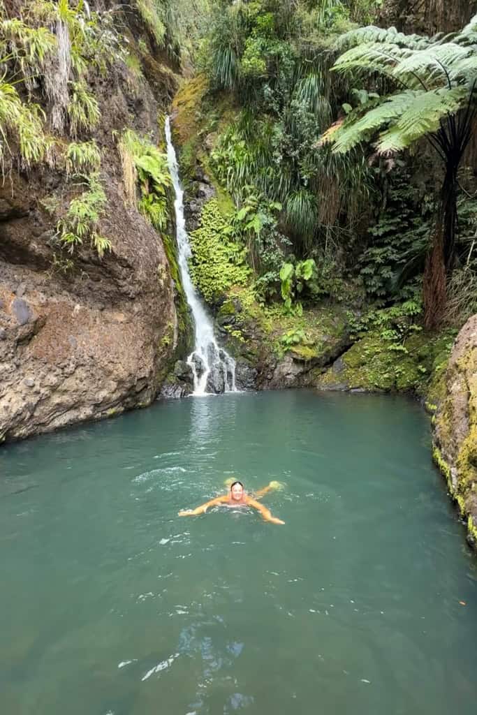 Girl swimming in the pool at the bottom of Karamatura Falls.