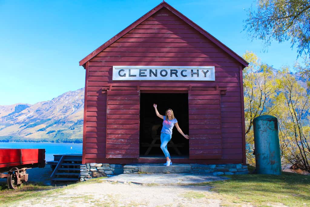 Girl standing in front of the red shed in Glenorchy.