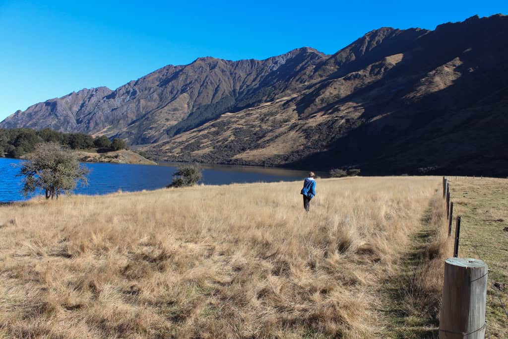 Girl running through the grass along the Moke Lake walk near Queenstown