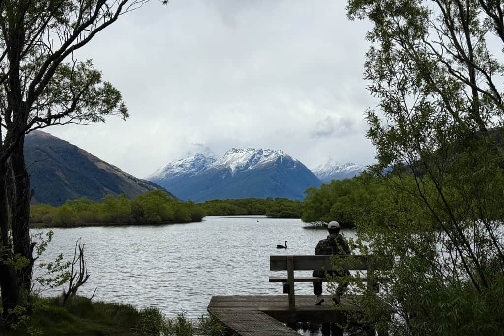 Man sitting on the bench along the boardwalk at the Glenorchy Lagoon.