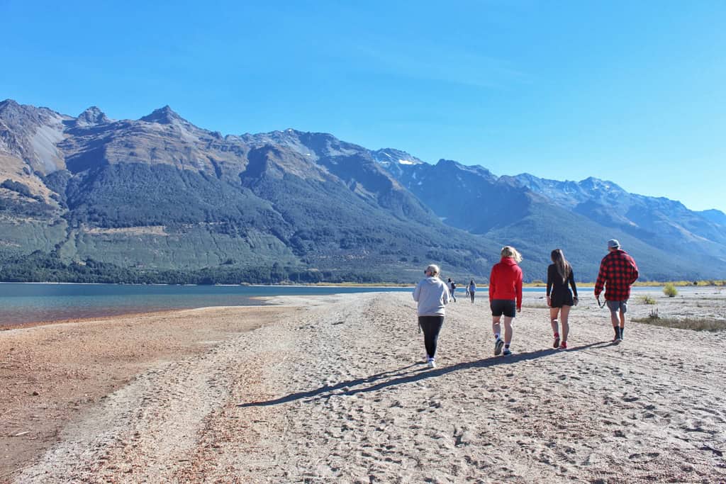 4 people walking along the lakefront in Glenorchy.