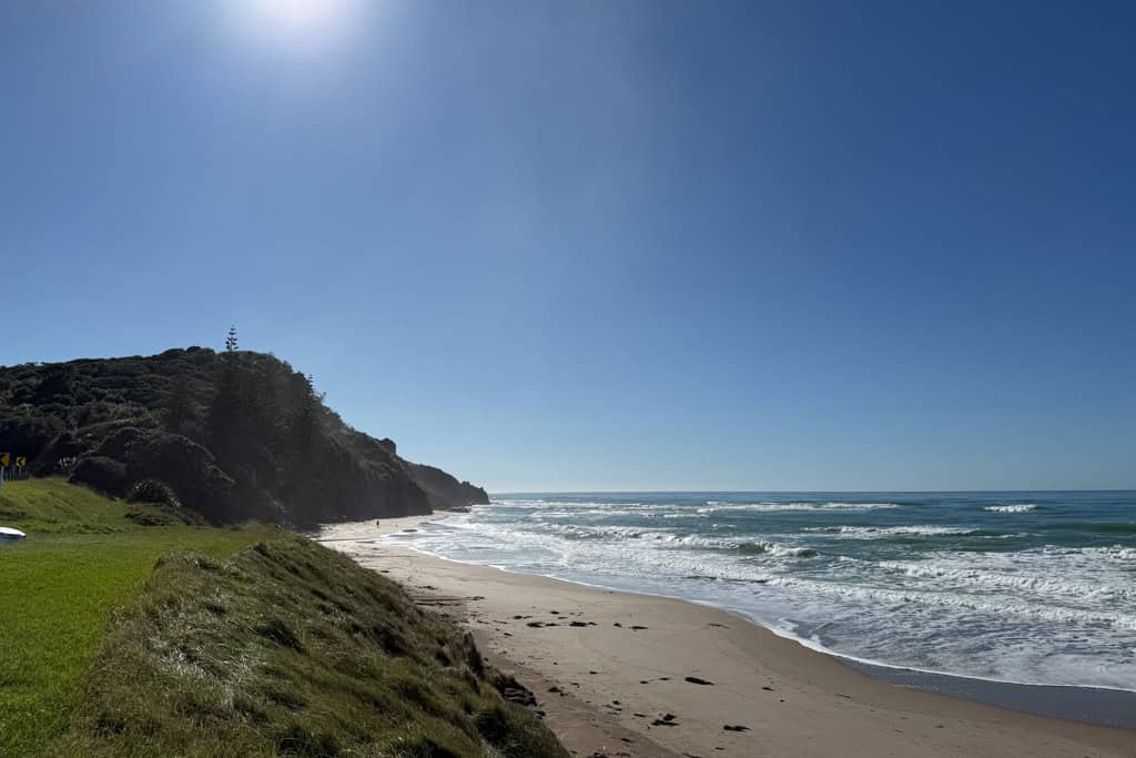 The waves crashing onto the sand at the beach in Gisborne.