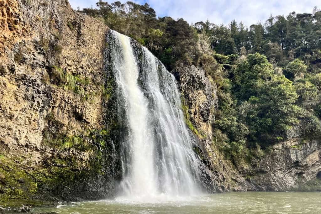 Hunua Falls crashing into the water below.