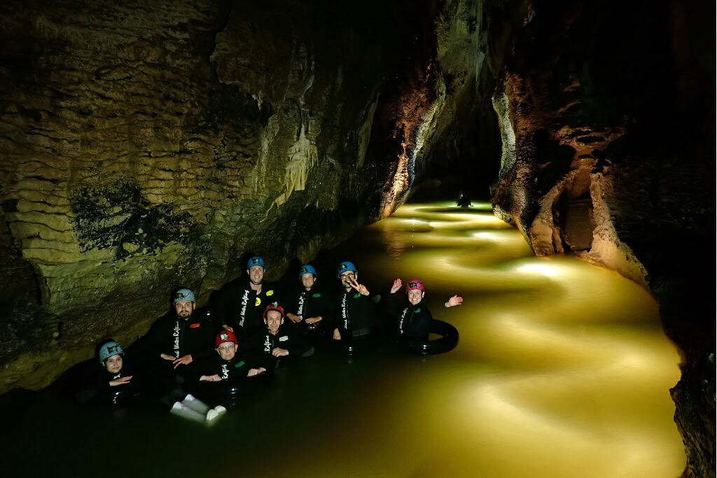 A group of people in a cave doing black water rafting.