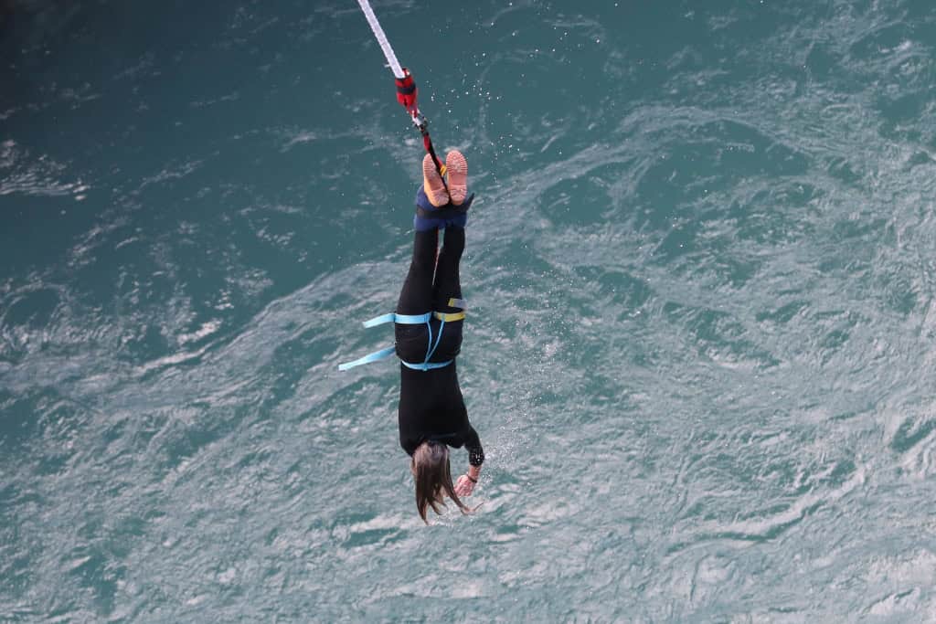 A person bungy jumping over the water at the Auckland Harbour Bridge Bungy.