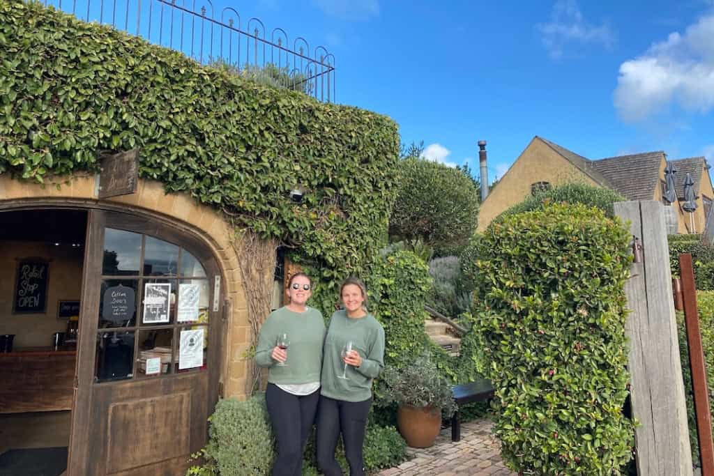 Two women hold a glass of wine at one of the wineries on Waiheke.