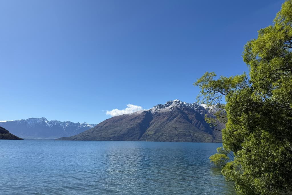 Looking over the lake towards the snow capped mountains on a suny day in Queenstown.