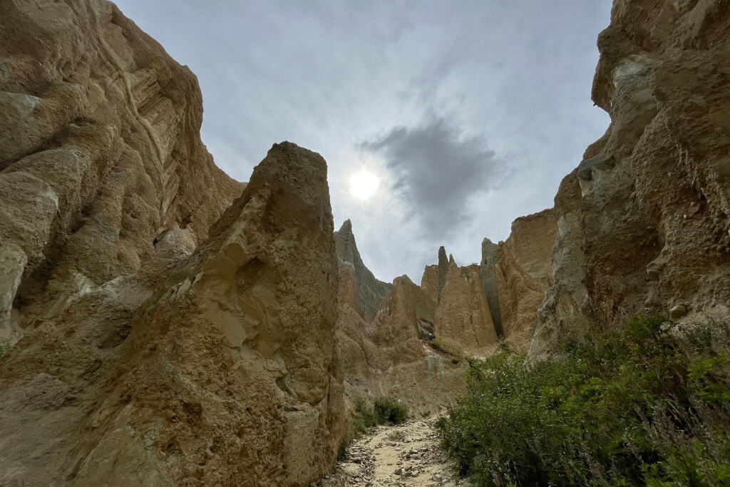 The track leads through as the Clay Cliffs tower above.