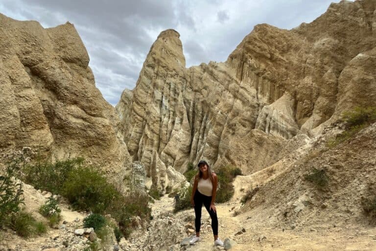 Woman standing in front of the Omarama Clay Cliffs.
