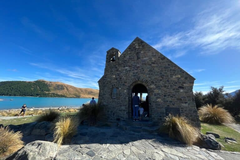A small stone church sitting on the edge of Lake Tekapo