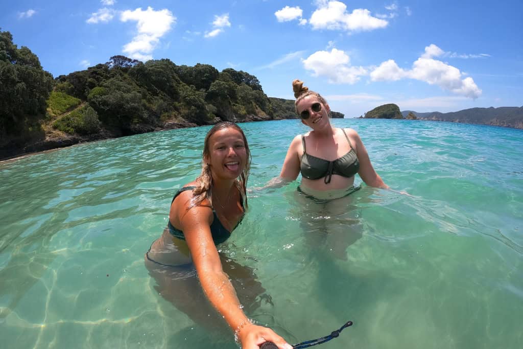 Two women swimming in the clear water at Oke Bay.