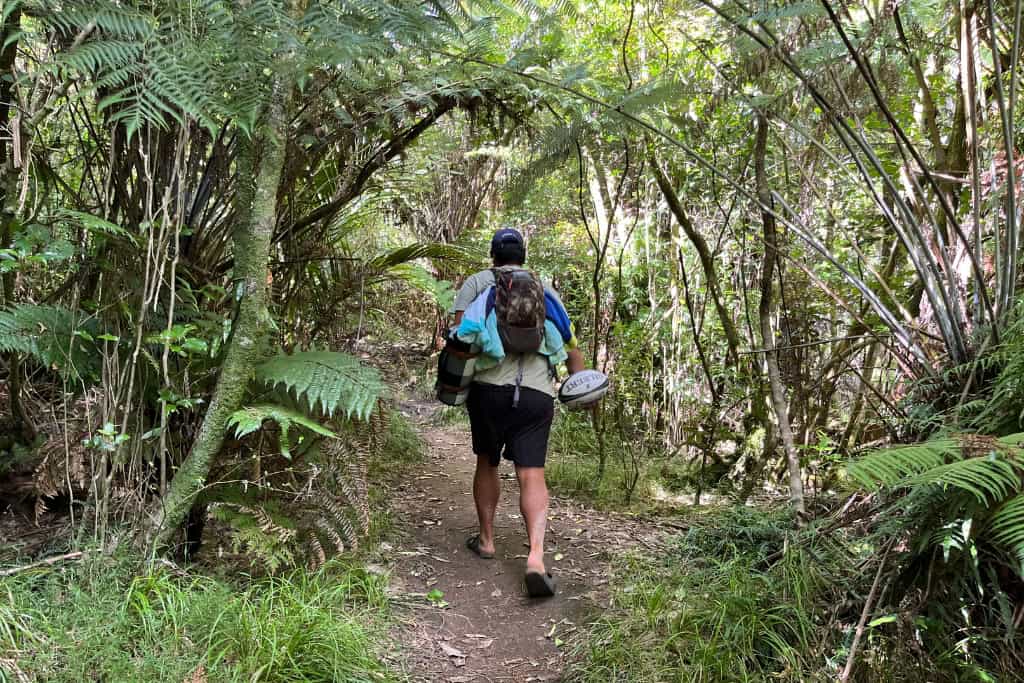 Man walking up the track that leads to the beach.