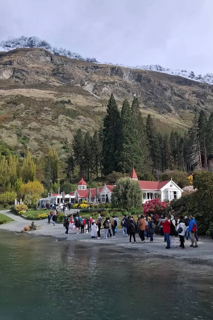 People walking towards the farm house on the edge of the lake.