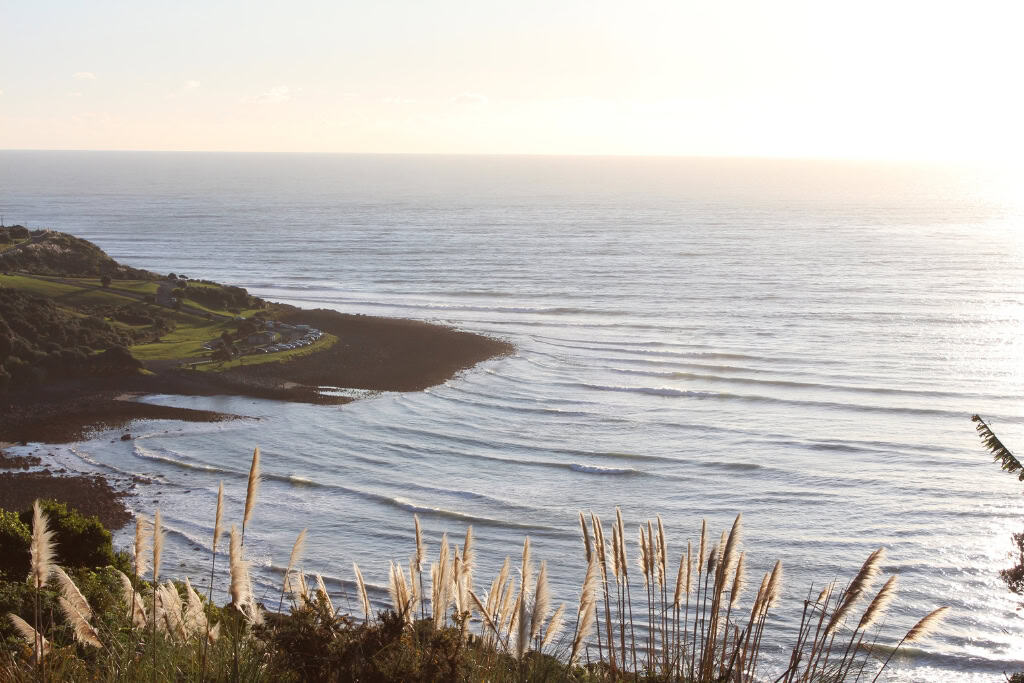 The waves crashing on Manu Bay at sunset.