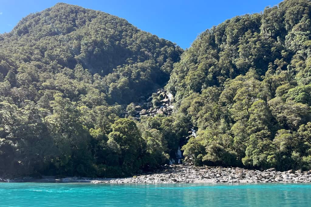 Roaring Billy Falls with the bright blue water running underneath it.