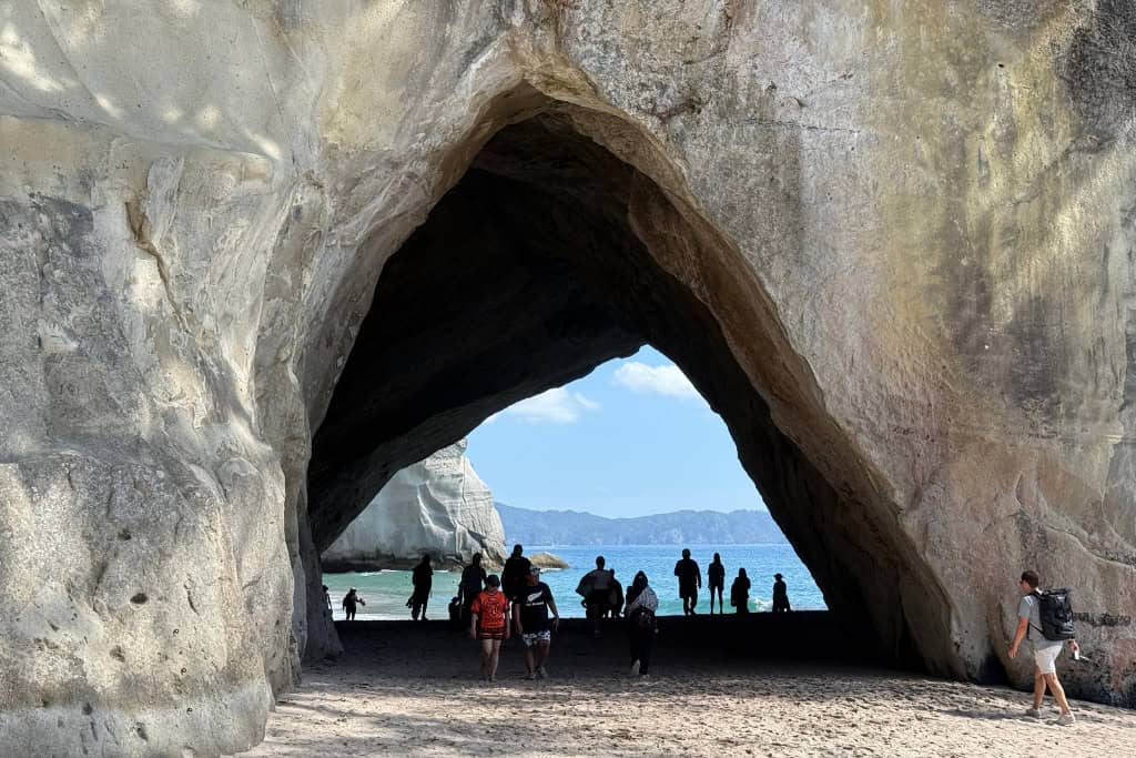 The archway filled with people as they walk to Cathedral Cove.