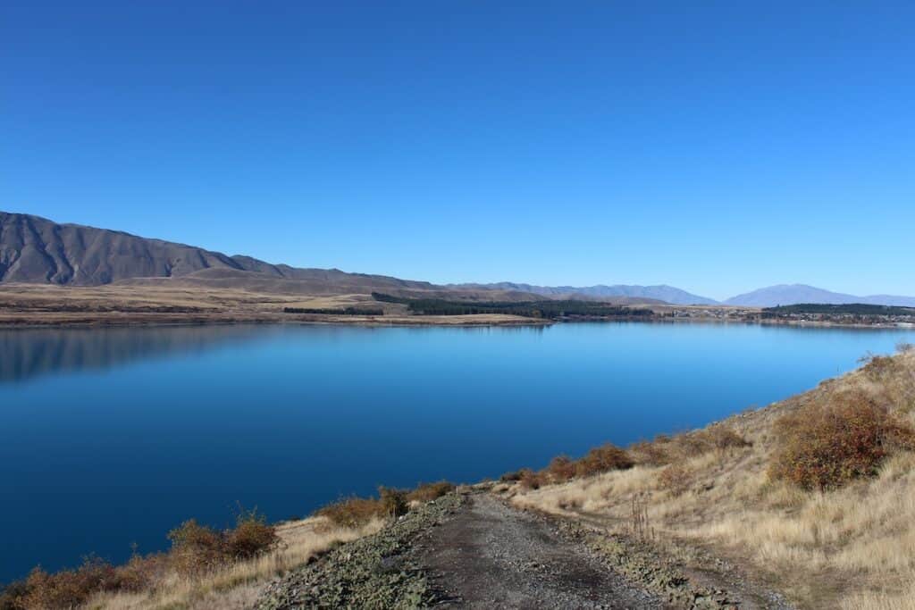 The blue lake reflecting the surrounding mountains.