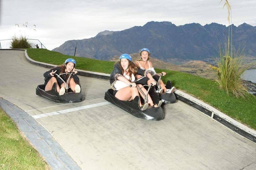 3 girls racing down the hill on the Luge in Queenstown.