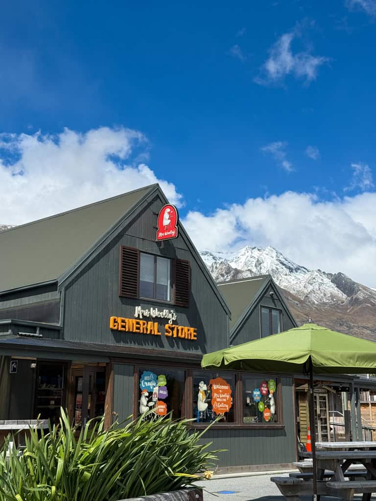 The popular Mrs Woollys shop and cafe in Glenorchy with snowy mountains in the background.