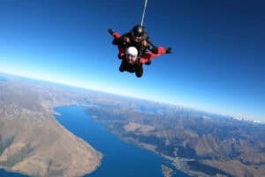 A person sky diving over Queenstown.