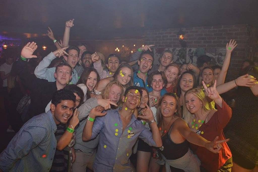 A large group of people posing for a photo during the pub crawl in Queenstown.