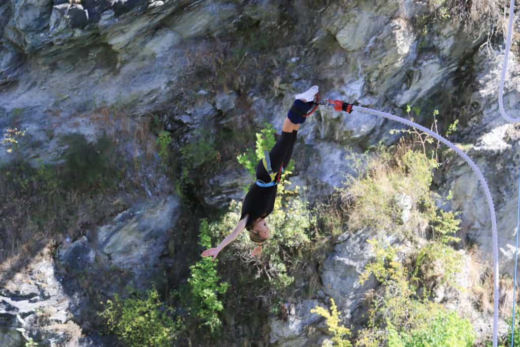 Woman looking excited as she dives down on her bungy jump.