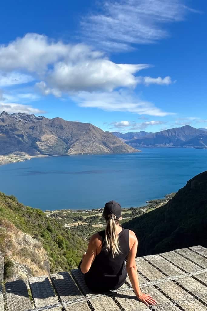 Woman sitting on the platform at the top of they Wye Creek walk looking out at the lake and mountains.