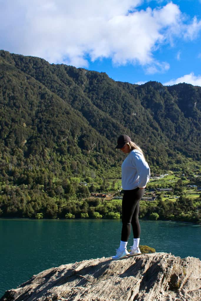 Woman standing at the lookout on the Bob's Cove track looking at the blue Lake.
