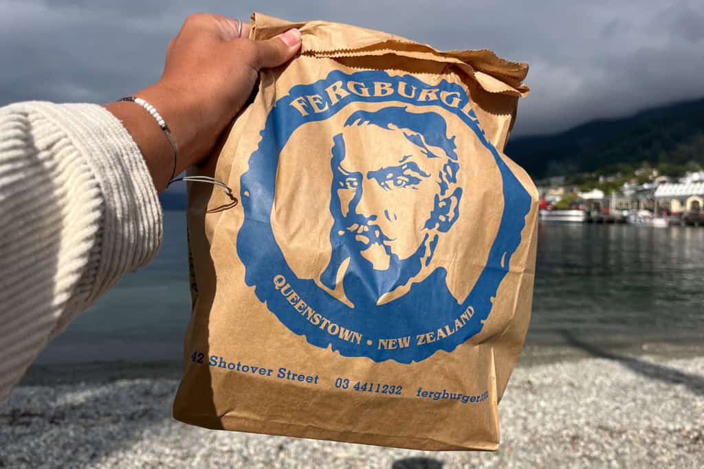 A burger bag with the blue Ferg Burger logo on it.