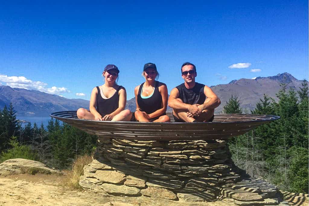 3 people sitting in a wire basket after walking the Queenstown Hill hike.