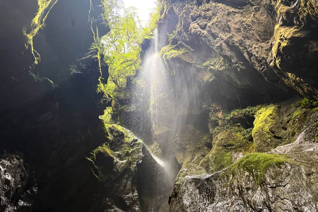 Water falls through the rocks at the secret South Island road side stop Wilson Creek Chasm.