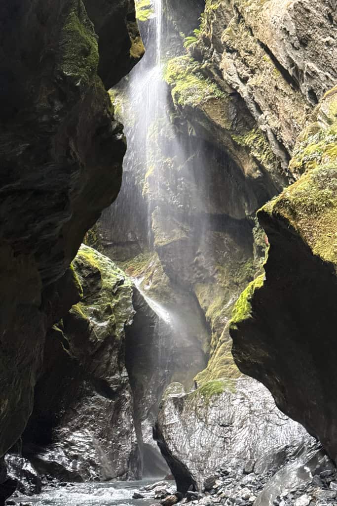 The view up the stream between the tall rock walls to the small waterfall.