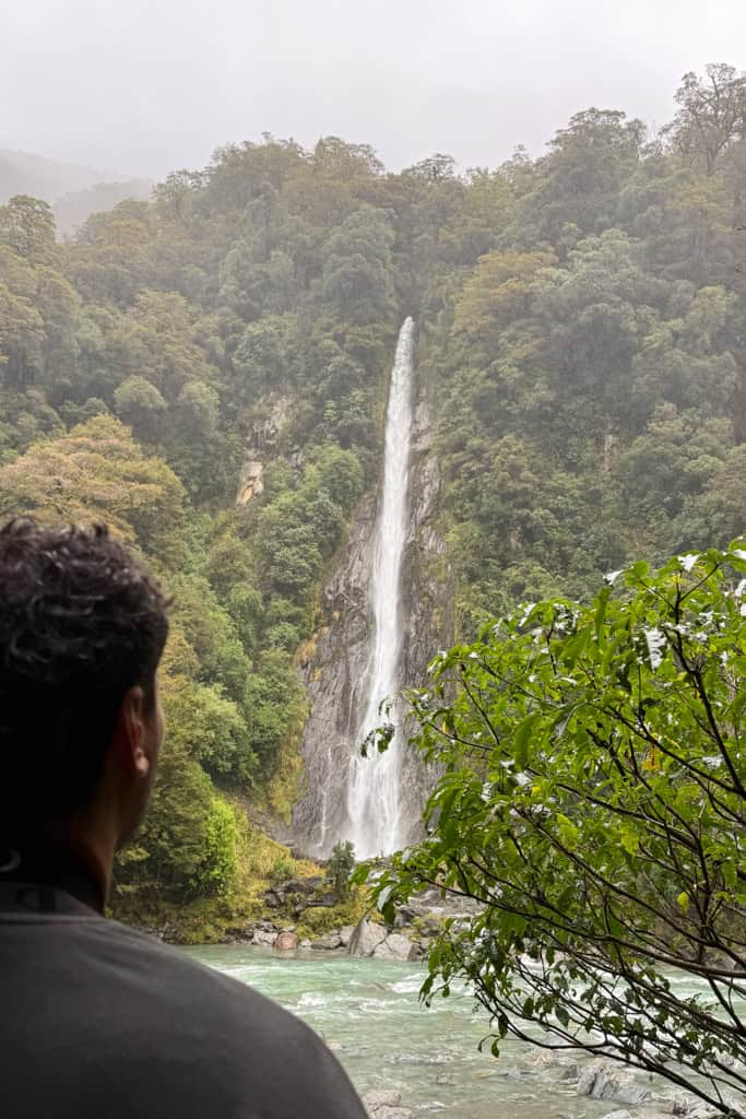 A man looking at Thunder Creek falls from the Lookout.