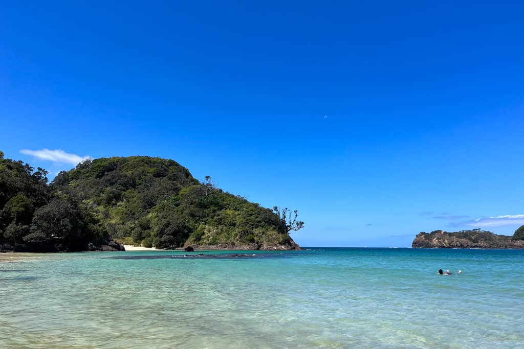 Clear blue water with the beach in the background at Matapouri.